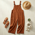 Salopette large en coton lin terracotta rouge en flat-lay avec chapeau de paille et sandales